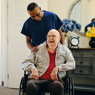 Young NEMT operator helping a patient out of the facility
