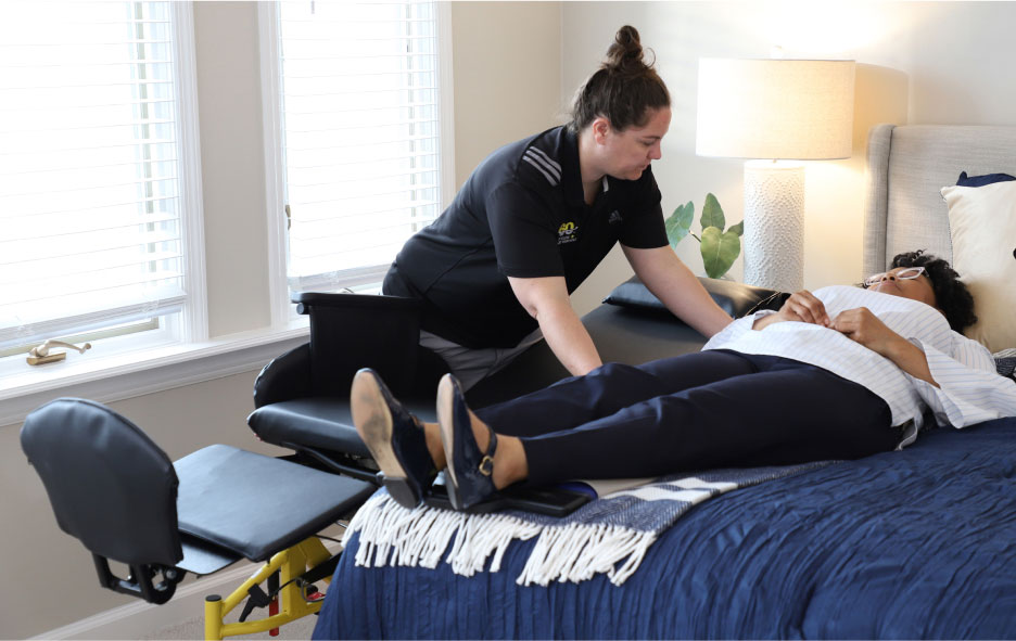 Healthcare Worker Assisting a Women Move From The Traversa Wheelchair to Her Bed