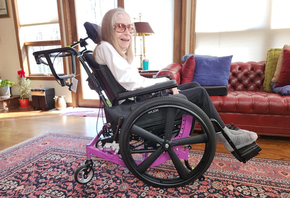 Elderly woman in a custom pink wheelchair.
