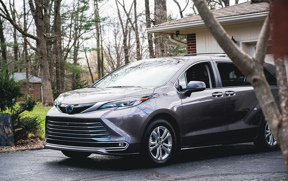 A minivan backed up to a home.