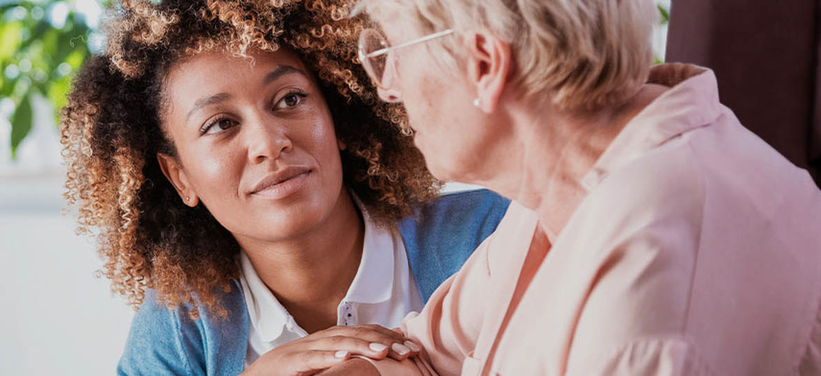 A caregiver kneeling alongside a patient