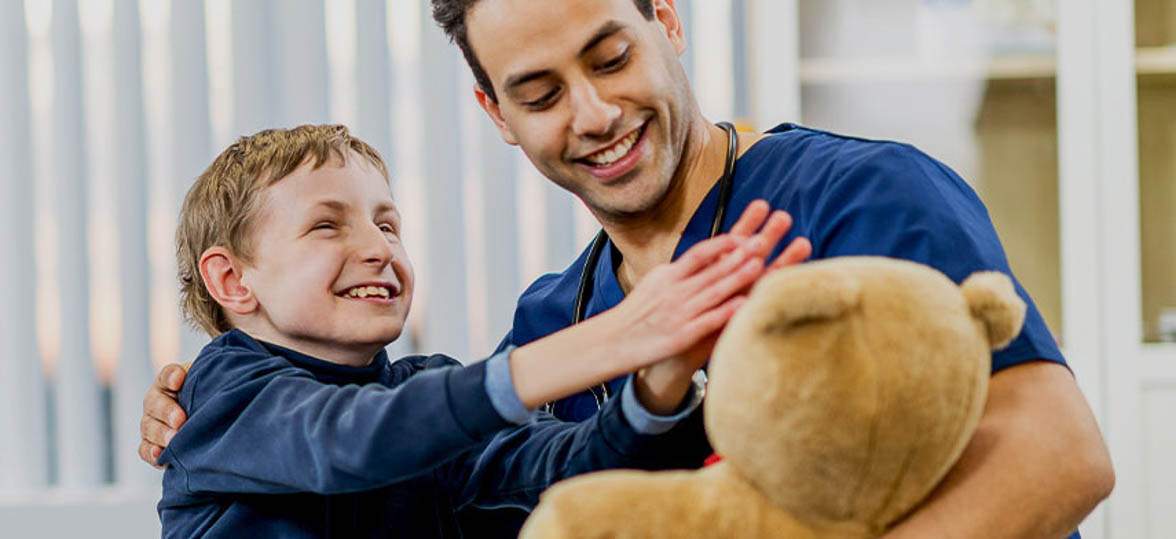 A young boy with autism and blindness in the arms of a caregiver