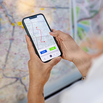 Person comparing phone map route to a map on the wall