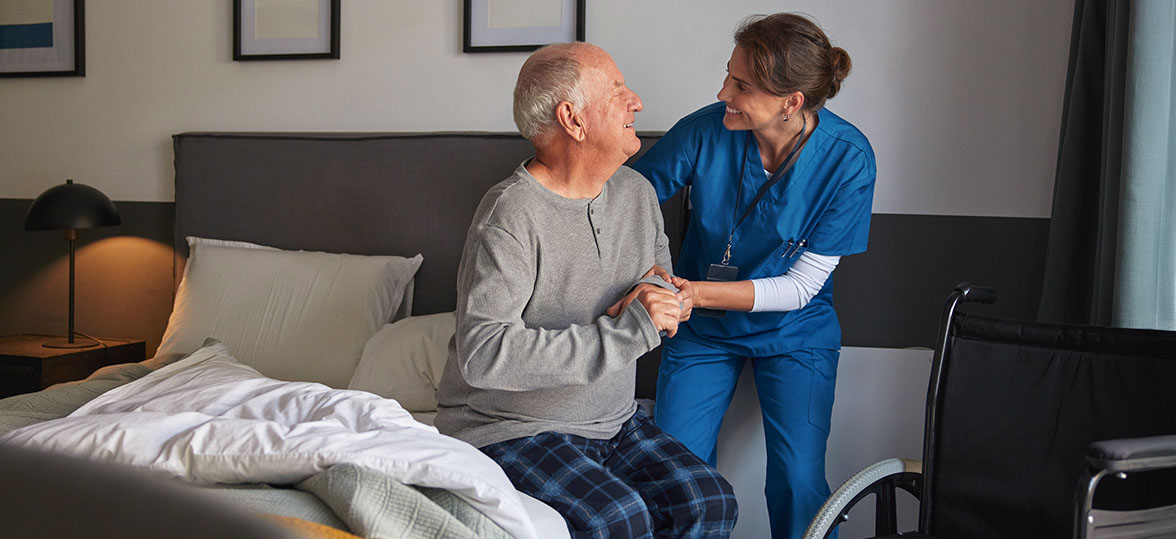 Healthcare workers helping a patient out of bed