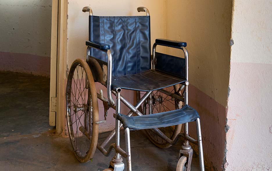 Old, worn wheelchair in empty room