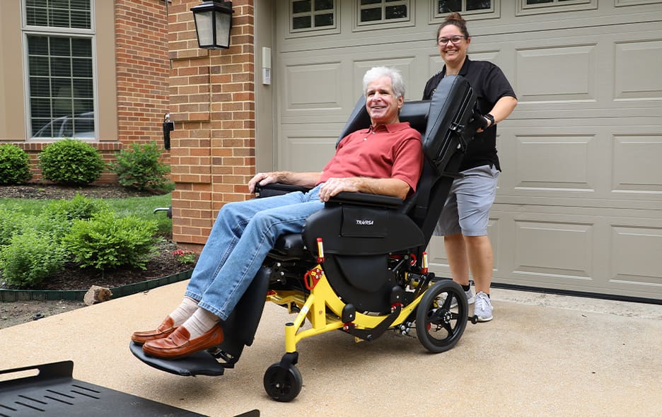 NEMT Operator standing and smiling next to a passenger in the Traversa