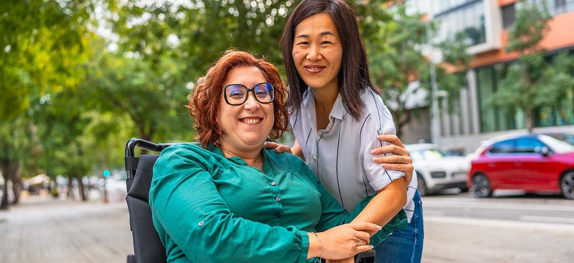 A woman in a wheelchair outside with a friend