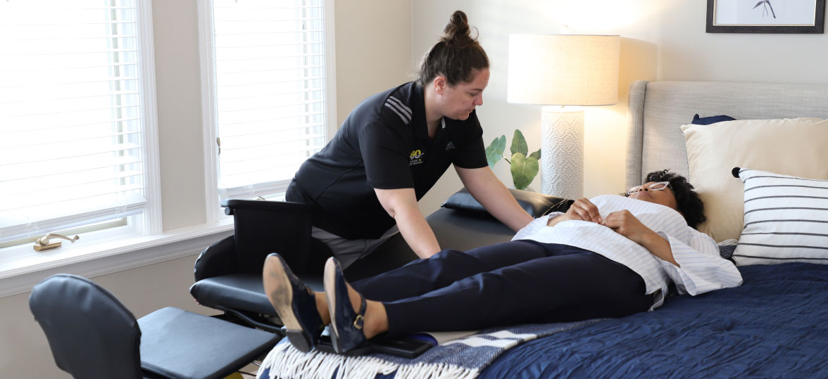 Healthcare Worker Assisting a Women Move From The Traversa Wheelchair to Her Bed