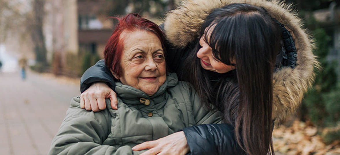 Aging senior woman outside with family